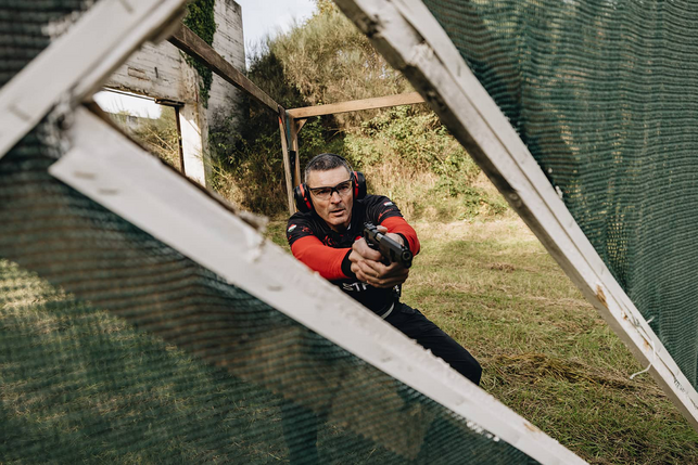 György Batki on a shooting range, reloading his pistol
